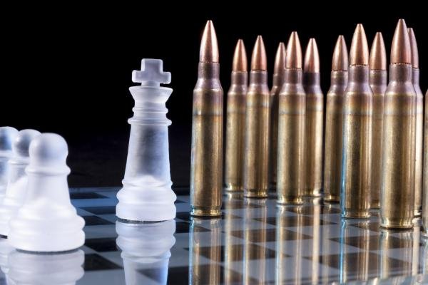 Tablero de ajedrez sobre el cual hay piezas y balas.