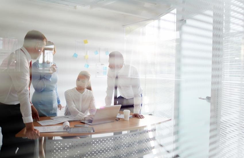 Grupo de personas al interior de una oficina muy iluminada.