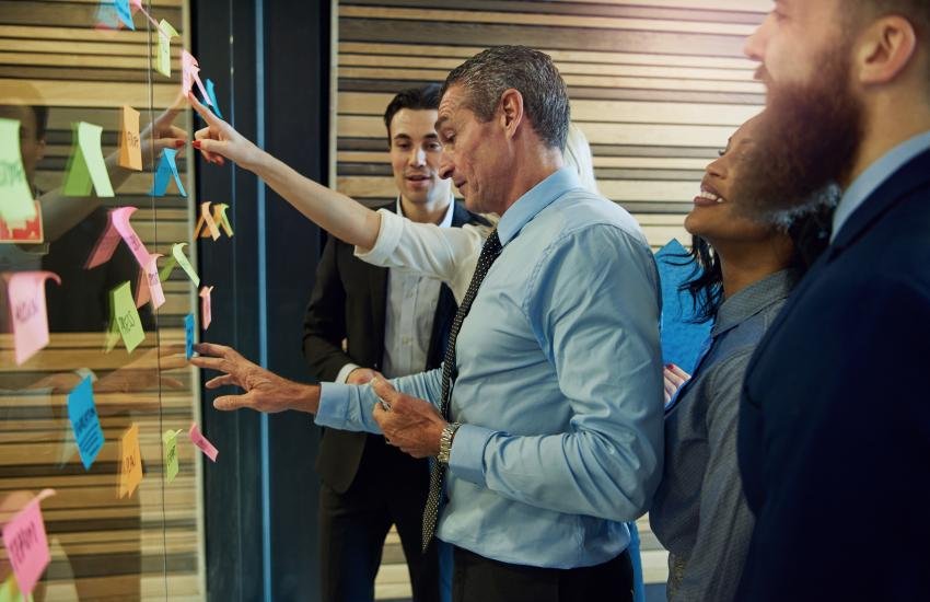 Jefe con su equipo de trabajo elaborando un plan.